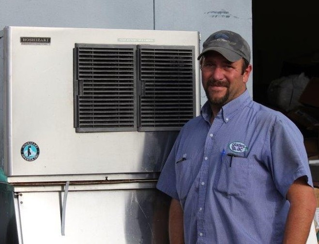 Picture of worker in front of an ice machine